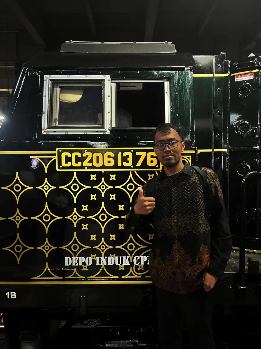 Dhiya di samping lokomotif CC206